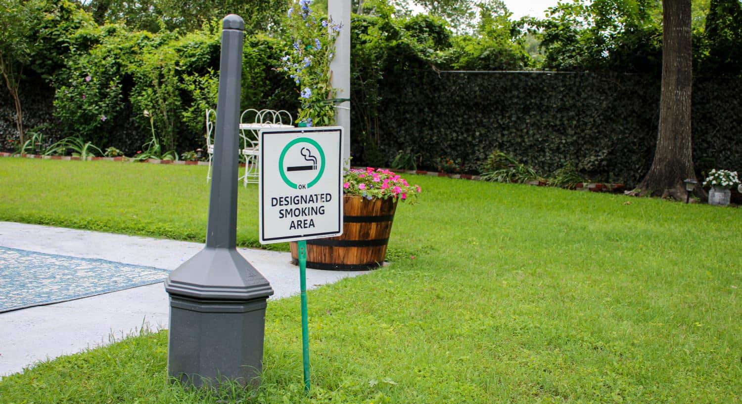 Backyard with green grass and a sign for designated smoking area