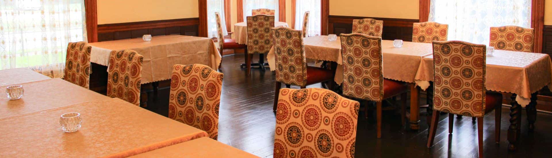 Close up view of multiple tables and chairs in a dining room