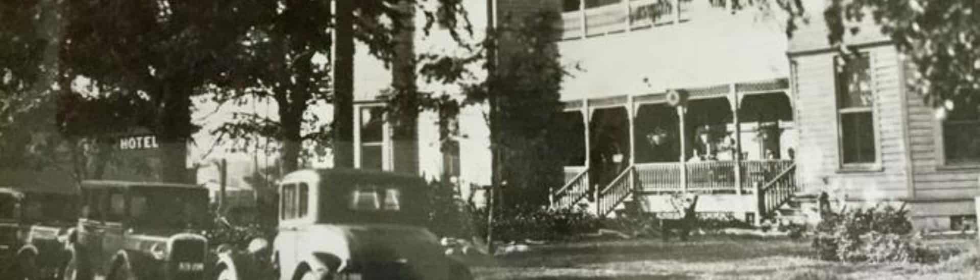 Black and white view of the property with classic cars from the 20s or 30s parked out front